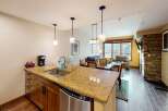 This stunning kitchen features a granite countertop, stainless steel appliances, and modern pendant lighting, perfect for preparing meals and entertaining guests.