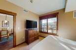 This inviting bedroom features a large window offering stunning views and ample natural light.