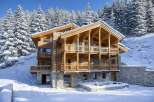 This stunning wooden chalet offers a luxurious retreat in a snowy mountain setting.