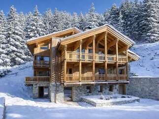 This stunning wooden chalet offers a luxurious retreat in a snowy mountain setting.