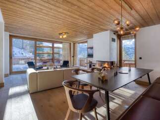Experience luxury living in this stunning property, featuring a cozy fireplace and a modern dining area.