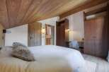 This stunning bedroom boasts a warm and inviting ambiance with its wooden ceiling and walls.
