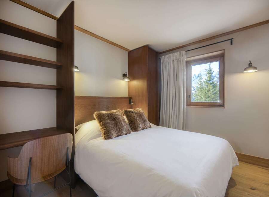 This cozy bedroom features a comfortable bed with fluffy pillows, perfect for a relaxing stay.