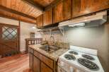 Step into this charming kitchen, featuring warm wooden cabinetry and a classic stove.