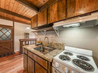 Step into this charming kitchen, featuring warm wooden cabinetry and a classic stove.
