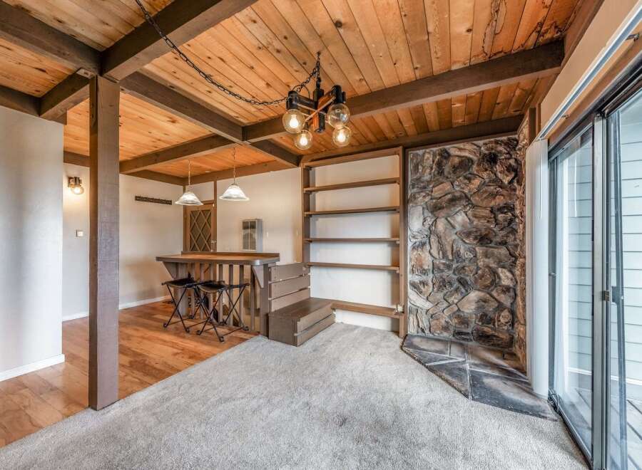 Step into this charming space featuring a rustic stone fireplace and a cozy bar area, perfect for entertaining.