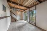 Discover the charm of this inviting living space, featuring a unique wooden ceiling and a cozy carpeted floor.