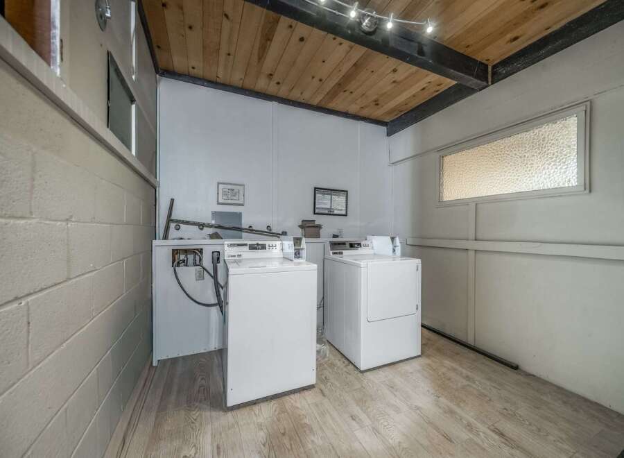 This laundry room features two washing machines and a dryer, perfect for convenient in-unit laundry.