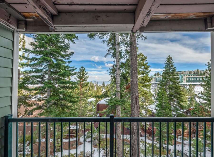Enjoy breathtaking views from this stunning property! This home offers a serene escape with a balcony overlooking a picturesque landscape of snow-covered trees and distant buildings.