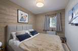 This cozy bedroom features a rustic wooden wall design and a comfortable bed with plush bedding.