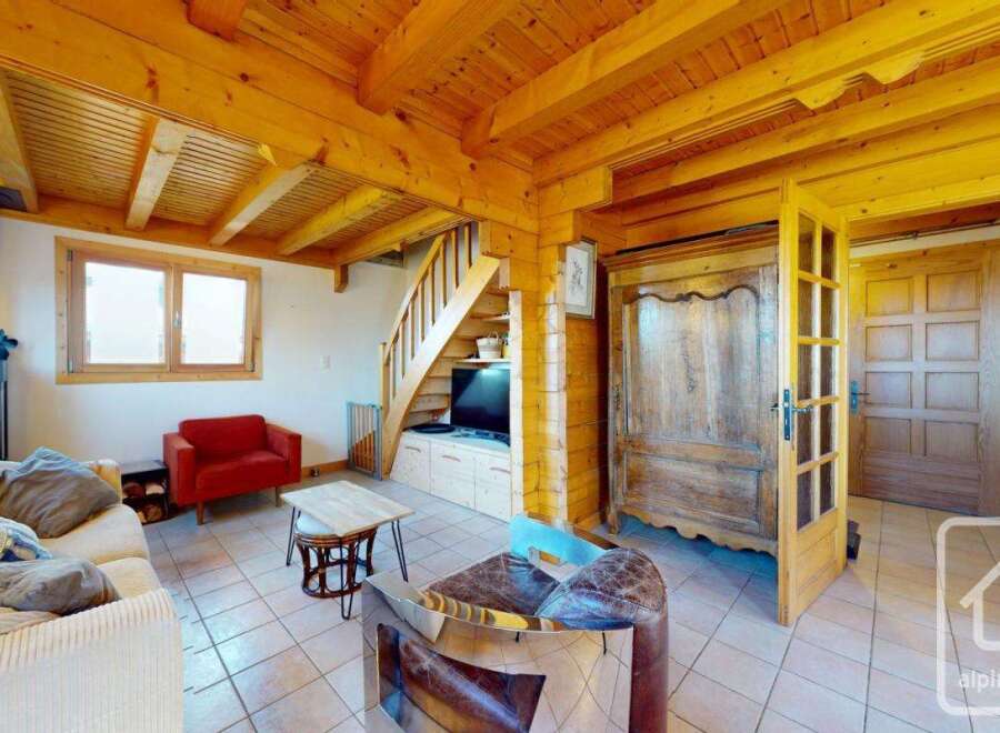 Discover the charm of this cozy living space, featuring a rustic wooden ceiling and a warm, inviting atmosphere.
