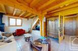 Discover the charm of this cozy living space, featuring a rustic wooden ceiling and a warm, inviting atmosphere.