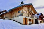Discover a stunning chalet nestled in a snowy landscape, perfect for a winter getaway.