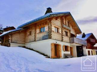 Discover a stunning chalet nestled in a snowy landscape, perfect for a winter getaway.