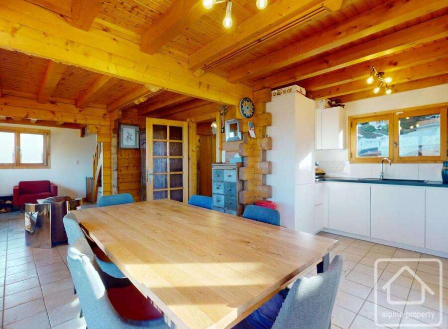 Experience the charm of this stunning property, featuring a spacious dining area with a large wooden table, perfect for gatherings.