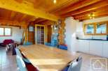 Experience the charm of this stunning property, featuring a spacious dining area with a large wooden table, perfect for gatherings.