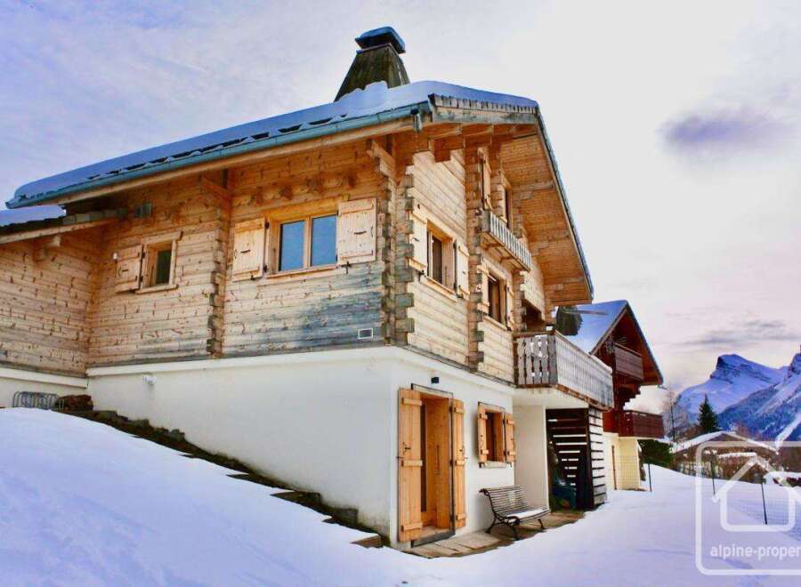 Discover the charm of this stunning wooden chalet nestled in a snowy landscape.