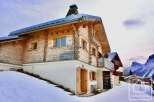 Discover the charm of this stunning wooden chalet nestled in a snowy landscape.