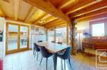 Discover the charm of this stunning property, featuring a spacious dining area with a wooden table and comfortable seating.