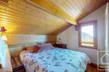 Discover the charm of this cozy bedroom, featuring a unique wooden ceiling and walls that exude warmth and character.