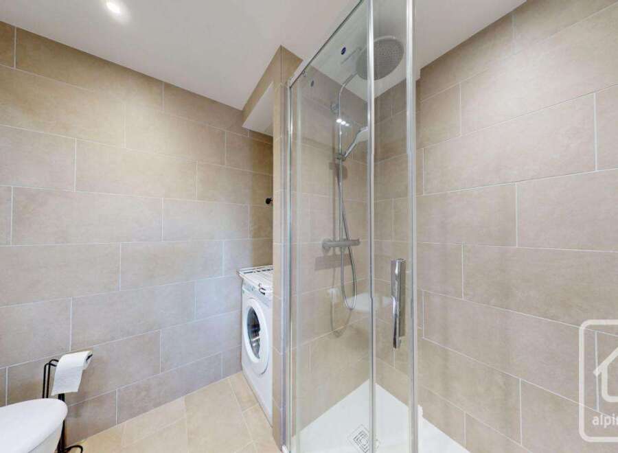 This modern bathroom features a sleek glass shower enclosure, perfect for a refreshing start to your day.