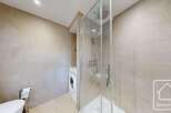 This modern bathroom features a sleek glass shower enclosure, perfect for a refreshing start to your day.