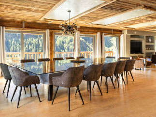 Experience luxury living in this stunning property, featuring a spacious dining area with a modern glass table and stylish chairs.