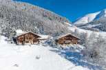 Nestled in a winter wonderland, this stunning property boasts two charming chalets, perfect for a luxurious mountain retreat.