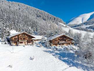 Nestled in a winter wonderland, this stunning property boasts two charming chalets, perfect for a luxurious mountain retreat.