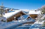 Nestled in a picturesque winter wonderland, this charming property boasts traditional wooden architecture and snow-covered roofs.