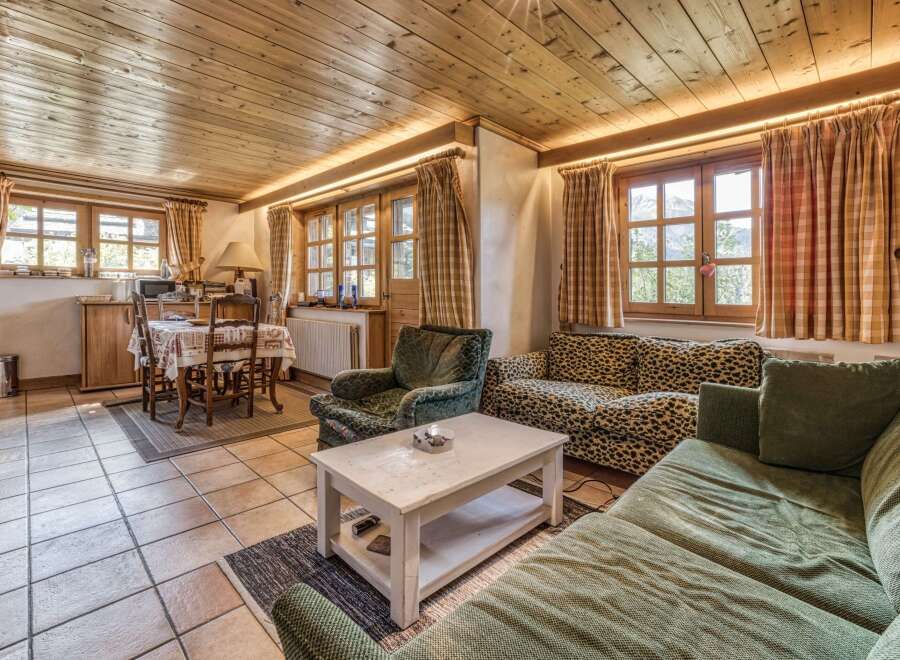 This cozy living space features a warm, inviting atmosphere with its wooden ceiling and tiled floors.