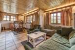 This cozy living space features a warm, inviting atmosphere with its wooden ceiling and tiled floors.