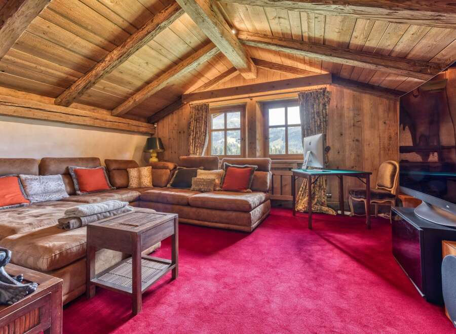 This stunning living space features a cozy, rustic design with exposed wooden beams and paneling, creating a warm and inviting atmosphere.