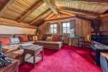 This stunning living space features a cozy, rustic design with exposed wooden beams and paneling, creating a warm and inviting atmosphere.