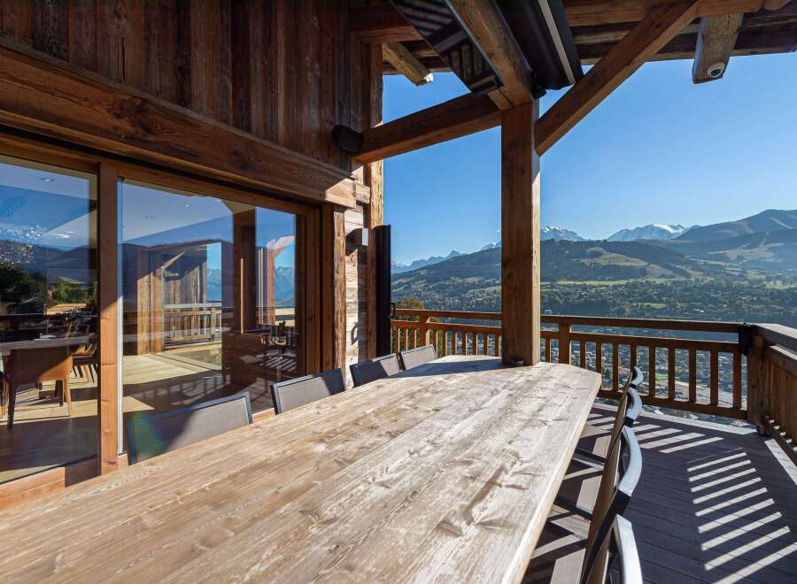 Enjoy breathtaking mountain views from this stunning chalet's expansive deck.