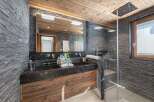 Experience luxury in this stunning bathroom featuring a sleek black marble vanity and a spacious walk-in shower.