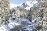 Nestled in a serene winter wonderland, this property offers breathtaking views of snow-capped mountains and a tranquil river.