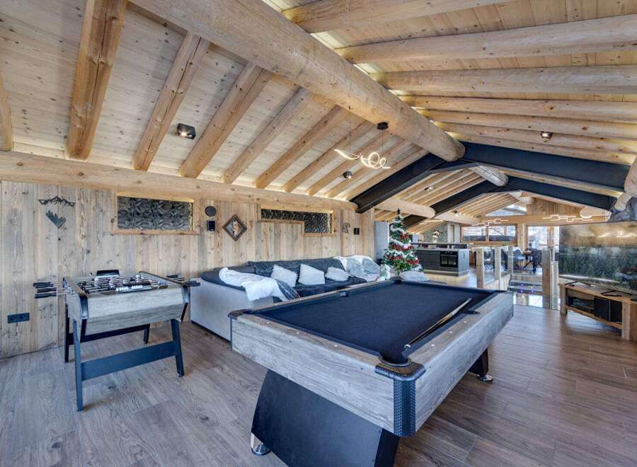 Experience luxury living in this stunning property featuring a game room with a pool table and foosball.