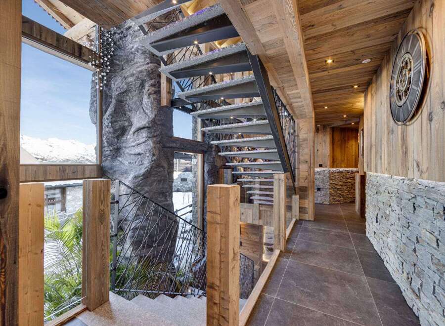 Step into luxury with this stunning property featuring a unique staircase design and exquisite wooden accents.