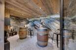 Discover the rustic charm of this unique wine cellar, featuring exposed stone walls and wooden barrel accents.