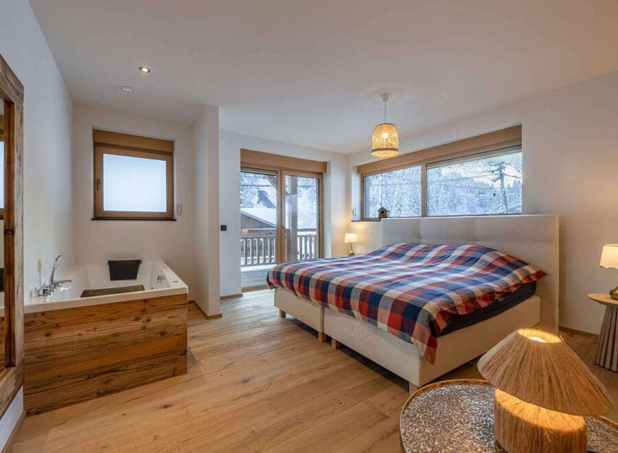 Experience luxury living in this stunning property featuring a spacious bedroom with a cozy bed and a private jacuzzi.