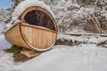 Experience the ultimate relaxation in this unique barrel sauna nestled in a snowy landscape.