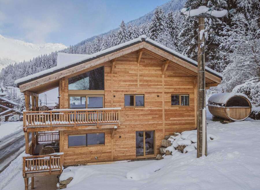 Experience the ultimate winter getaway in this stunning wooden chalet nestled in a snowy landscape.