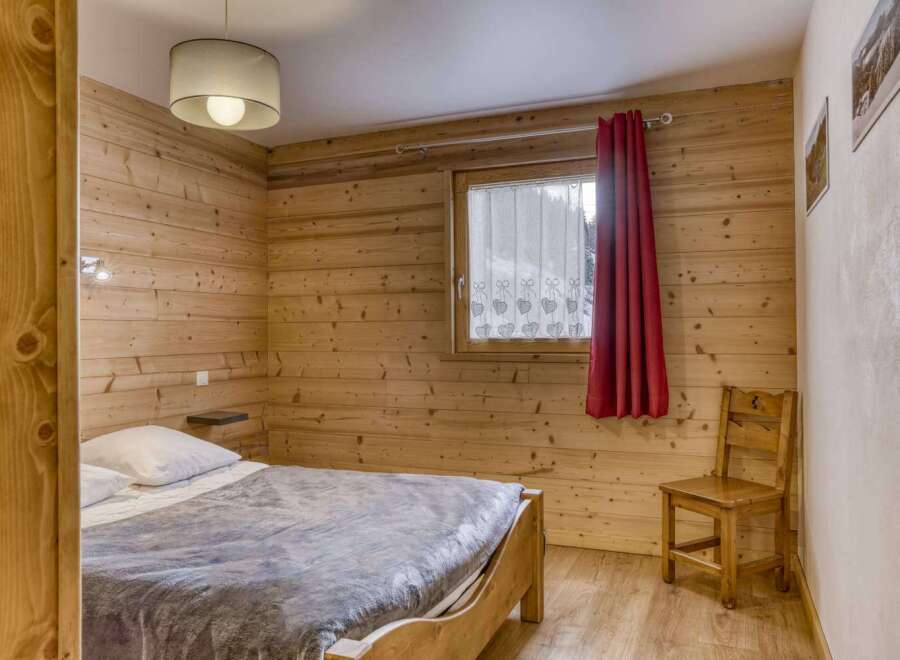 This cozy bedroom features beautiful wooden paneling, creating a warm and inviting atmosphere.