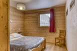 This cozy bedroom features beautiful wooden paneling, creating a warm and inviting atmosphere.