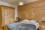 This cozy bedroom features a rustic wooden accent wall, creating a warm and inviting atmosphere.
