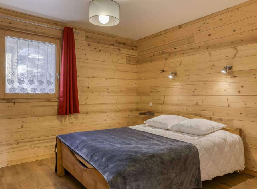 This cozy bedroom features beautiful wooden paneling, creating a warm and inviting atmosphere.