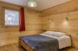 This cozy bedroom features beautiful wooden paneling, creating a warm and inviting atmosphere.