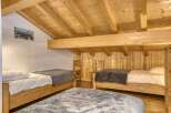 This charming bedroom features a cozy and inviting atmosphere with its wooden accents and natural light.