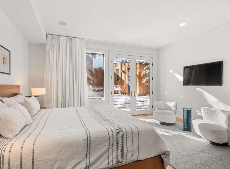 This stunning bedroom boasts a serene ambiance with its neutral color palette and ample natural light.